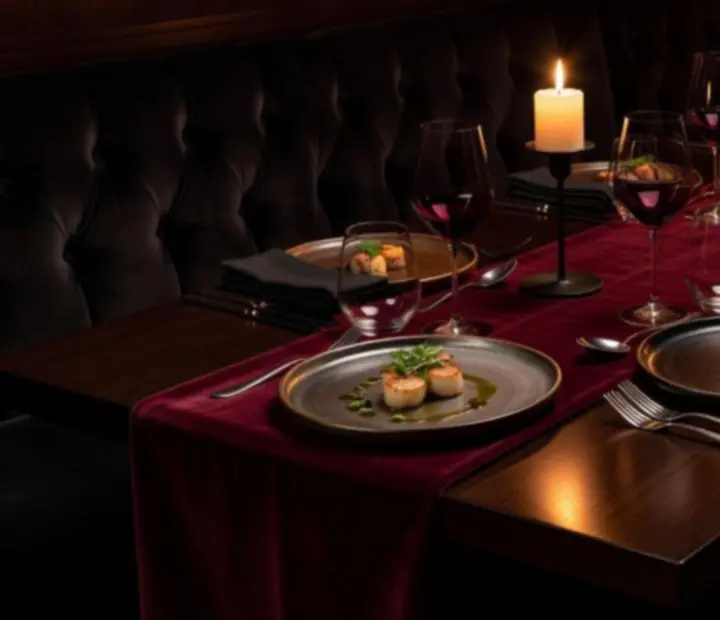 Candlelit dark supper dining table with modern Australian plates and cocktails