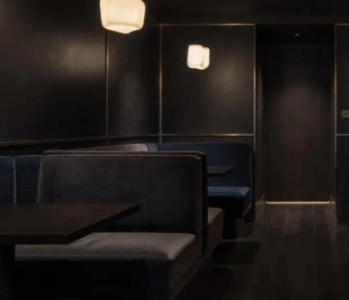 Dark velvet lounge interior with low lighting and intimate table settings